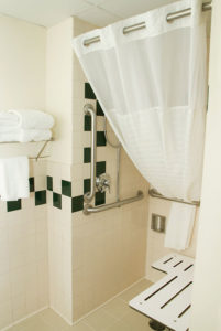 ADA accessible roll-in shower with grab bars and seat